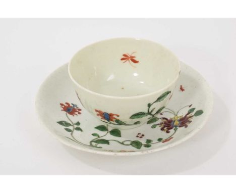 A Worcester Hibiscus pattern tea bowl and saucer, circa 1758, decorated with scroll emblem, large honeysuckle flower, trailin