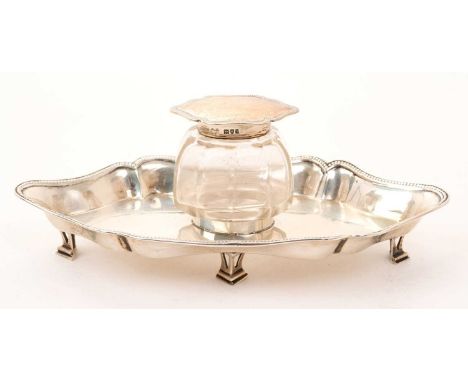 Early George V silver ink stand of shaped form, with bead border, on four open work feet, together with a silver mounted cut 
