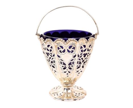 Victorian silver, swing handled sugar basket of fluted form, with pierced decoration and Bristol blue glass liner, on a shape