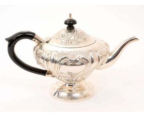 Edwardian silver teapot of inverted baluster form, with embossed foliate decoration and hinged domed cover, on a circular ped