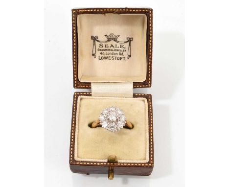 Diamond flower head cluster ring with a central brilliant cut diamond surrounded by a border of eight further brilliant cut d