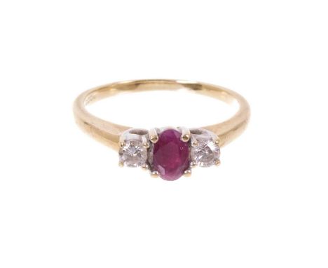 Ruby and diamond three stone ring with a central oval mixed cut ruby flanked by two brilliant cut diamonds in claw setting on