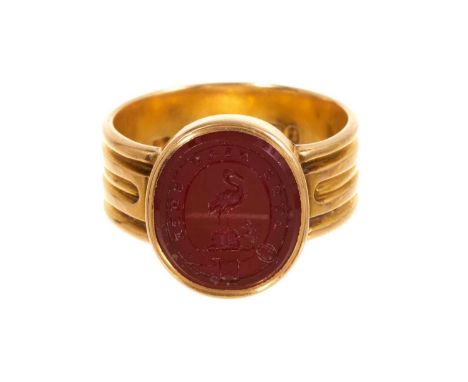 Victorian 18ct gold and intaglio carved carnelian signet ring, the oval seal with family crest and motto, in gold setting wit