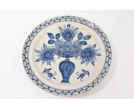 An 18th century Dutch Delft charger, painted in underglaze blue with a vase of flowers, 34.5cm diameter