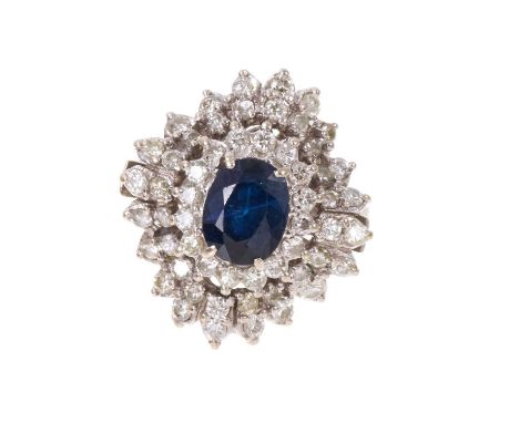 Sapphire and diamond cocktail ring an oval mixed cut blue sapphire measuring approximately 8.2mm x 6.5mm surrounded by fifty-