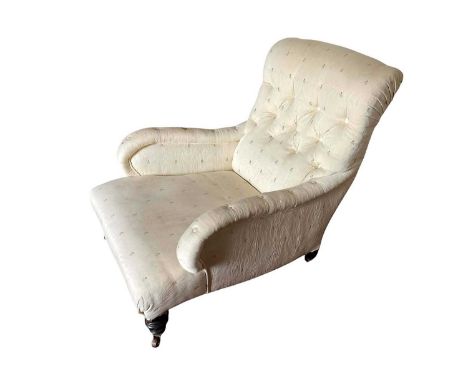 Victorian deep armchair in the manner of Howards, raised on turned legs and castorsUpholstery is grubby in places and with sl