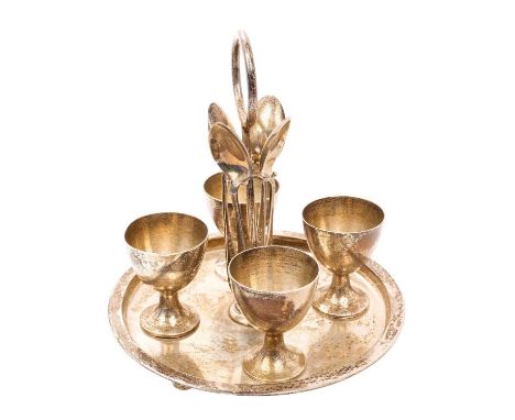 1920s silver egg cruet of circular form, with engraved dates and initials, central carrying handle, and fitted with four egg 
