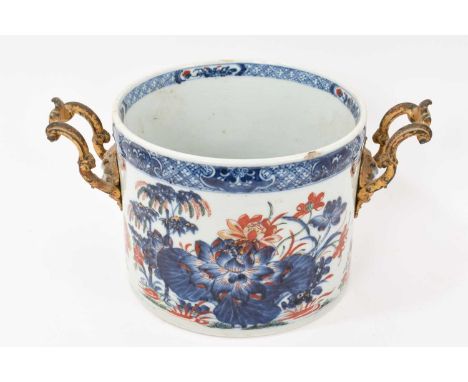 An 18th century Chinese porcelain jardiniere with later ormolu handles, painted in underglaze blue and enamels with flowers a