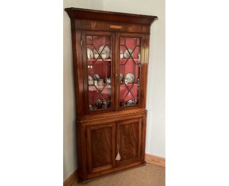Georgian floorstanding corner cabinet, with astragal glazed upper section enclosing shaped shelves, panelled doors below on p
