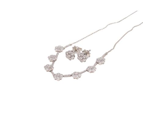 Diamond necklace and earrings, the necklace comprising seven daisy clusters of brilliant cut diamonds on a line of diamonds, 