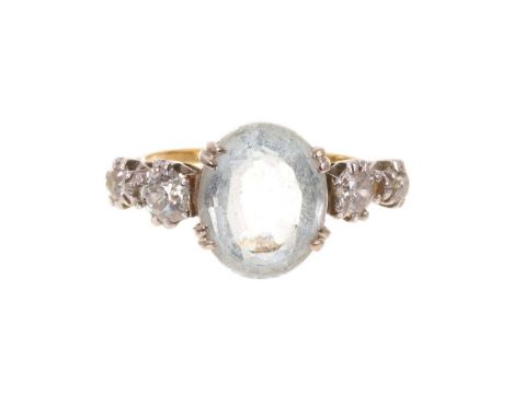 Edwardian aquamarine and diamond ring with an oval mixed cut aquamarine flanked by four old cut diamonds in platinum claw set