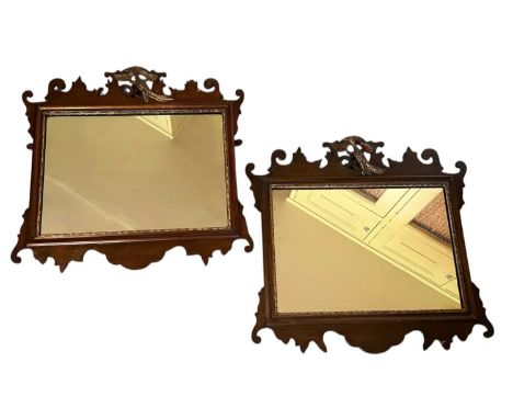 Pair of Georgian style Chippendale revival mahogany wall mirrors, with central gilt exotic bird, scroll moulded borders and g