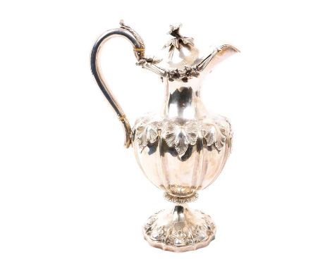 Victorian silver hot water jug of baluster form, with embossed foliate decoration and armorial shield, hinged domed cover and