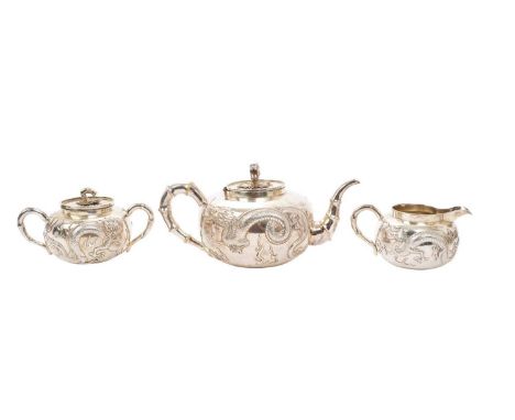 Late 19th/early 20th century Chinese silver three piece teaset, comprising teapot of melon form, with embossed dragon decorat