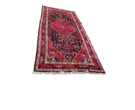 Large Hamadan carpet with central medallion and foliate field in claret red medallions and main foliate border, 375 x 165cmCo