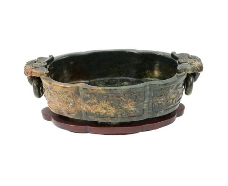 Large Chinese spinach jade marriage bowl, of shaped outline, with foliate reserves and twin ring handles, 30cm long, raised o