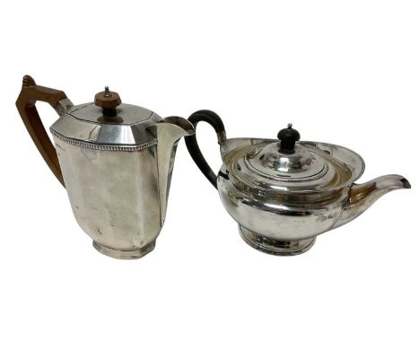 George V silver teapot of compressed baluster form, with flared border, hinged domed cover and ebony loop handle, on a circul