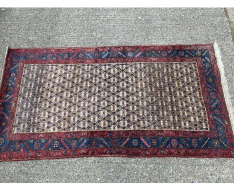 Eastern rug with lattice design ground and red and blue border, 230cm x 130cm