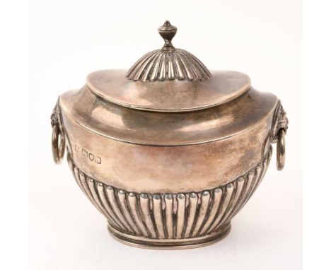 Victorian silver tea caddy of half fluted form, with hinged cover and side mounted lion mask handles, on an oval base (London