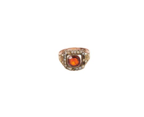 George III garnet and seed pearl ring with a cushion cut garnet surrounded by a border of seed pearls on gold acanthus leaf s