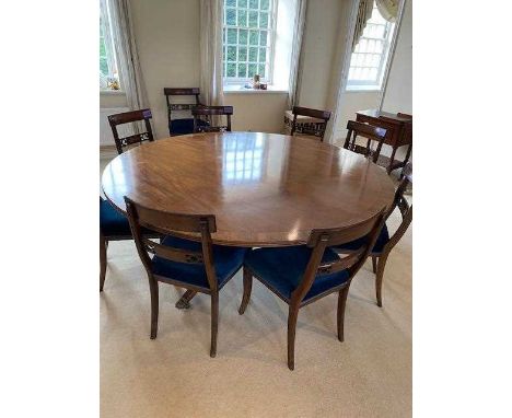 Regency style circular dining table, with expansive rosewood crossbanded top, on column supports and spread reeded legs on ca