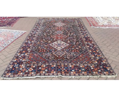 A Persian Qashqai kelleigh carpet, linked diamond medallions on dark brown field decorated with flora and fauna motif within 