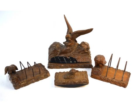 A German Black Forest wood desk set carved with eagles, comprising a pen stand incorporating two ink well with hinged covers,
