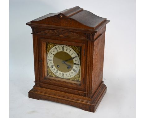 A German oak mantel clock, the eight-day two train movement by Lenzkirch striking on a spiral gong, 38 cm high