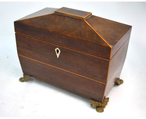 A Regency mahogany sarcophagus tea caddy with two lidded compartments, on ornate gilt brass claw feet, 20 cm wide