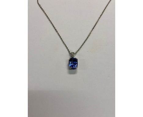 A cushion-cut sapphire pendant with diamond set hanger, white metal set, unmarked and untested, on 18ct white gold fine trace