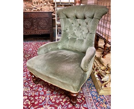 A Victorian green button backed nursing chair raised on turned front legs to brass castors, the back legs stamped 19390-9569