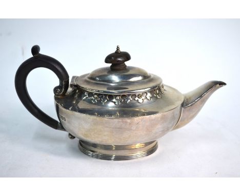 An oval silver bachelor teapot with Gothic-style embossed rim and reeded foot, Charles Edwards, London 1912, 11.4 oz gross