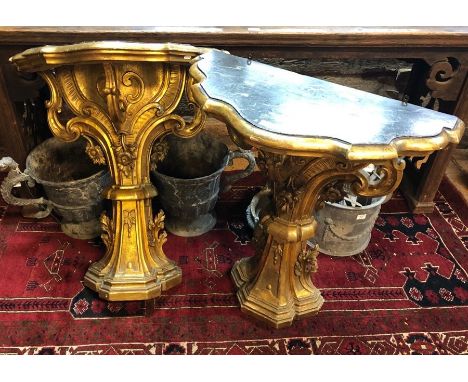 A pair of George III giltwood &nbsp;console tables of serpentine form, the faux marble painted tops over 71 cn wide x 82 cm h