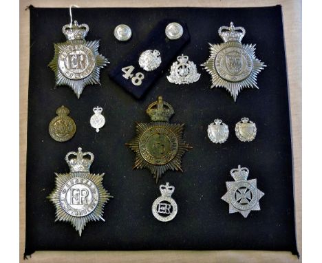 Police cap and helmet badges mounted on a board