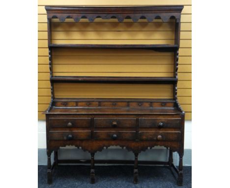 AN EARLY NINETEENTH CENTURY WELSH OAK DRESSER, the base with an arrangement of six drawers and five spice-drawers with shaped
