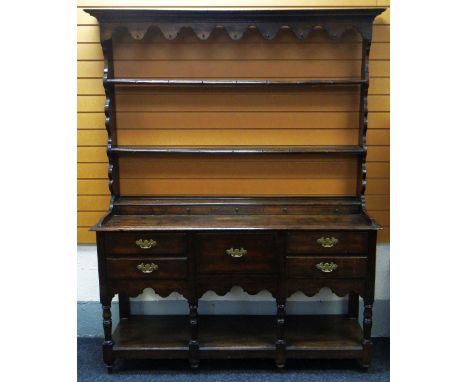 A NINETEENTH CENTURY WEST WALES OAK DRESSER having a base of two flanking drawers to a single centre deep drawer, all with br