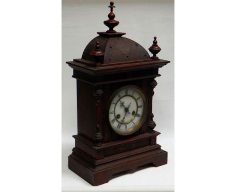 A BLACK-FOREST MANTEL CLOCK BY JUNGHANS with carved dome top, circular dial bearing Roman numerals, 52cms high
