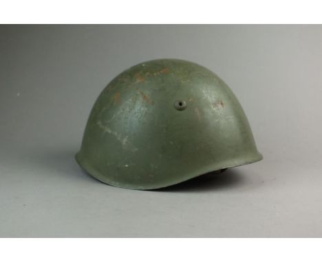 A WW2 Italian Steel Combat Helmet, retaining most of its original green paint finish to the exterior of the shell, helmet fit