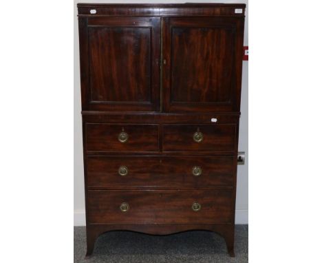 A George III Mahogany Dwarf Linen Press, early 19th century, with two cupboard doors enclosing an adjustable shelf above two 