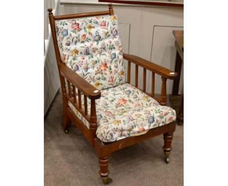 A Victorian Oak Framed Armchair, circa 1890, with spindle arm and back supports, the squab cushion above a plain seat rail, r