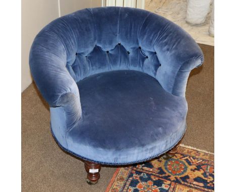 A Victorian Tub Framed Armchair, circa 1870, recovered in buttoned blue velvet with rounded back support and overstuffed seat