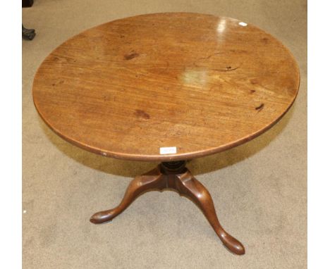 A George III Mahogany Circular Tripod Table, late 18th century, the flip top raised on a baluster tapering support with three