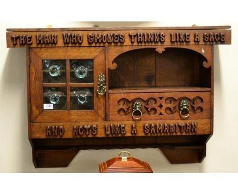 An Arts & Crafts Oak Wall Cabinet, late 19th century, carved with A MAN WHO SMOKES THINKS LIKE A SAGE AND ACTS LIKE A SAMARIT