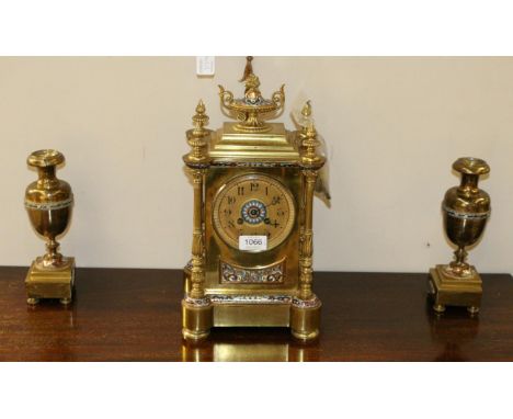 A Brass and Champleve Enamel Mantel Clock Garniture, late 19th century, of architectural form, surmounted by a twin handled u