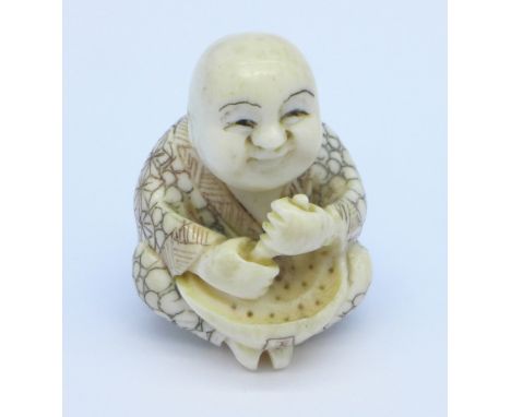 A carved ivory netsuke of a carpenter, signed