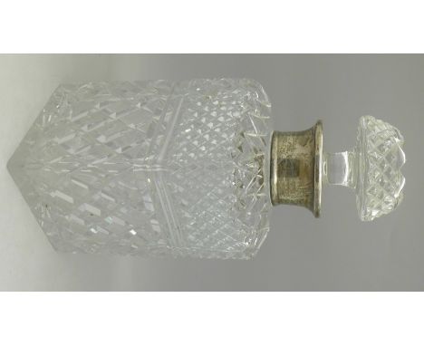 A silver rimmed cut glass decanter