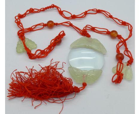 A magnifying glass with carved jade butterflies