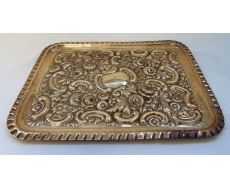 A Victorian hallmarked silver rounded rectangular dressing table tray chased with flowers, leaves and scrolls with everted cr