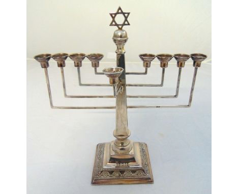 A hallmarked silver Menorah of customary form on raised square base with rosette and husk border, London 1951, approx total w