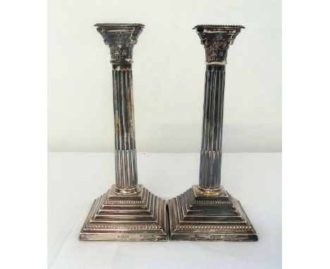 A pair of hallmarked silver Corinthian table candlesticks on stepped square bases with gadrooned borders London 1963, 29.5cm 